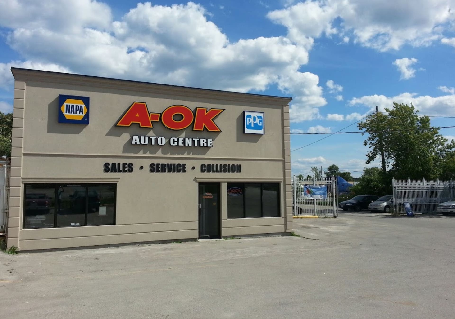 A tan building with the words aok auto center on it.