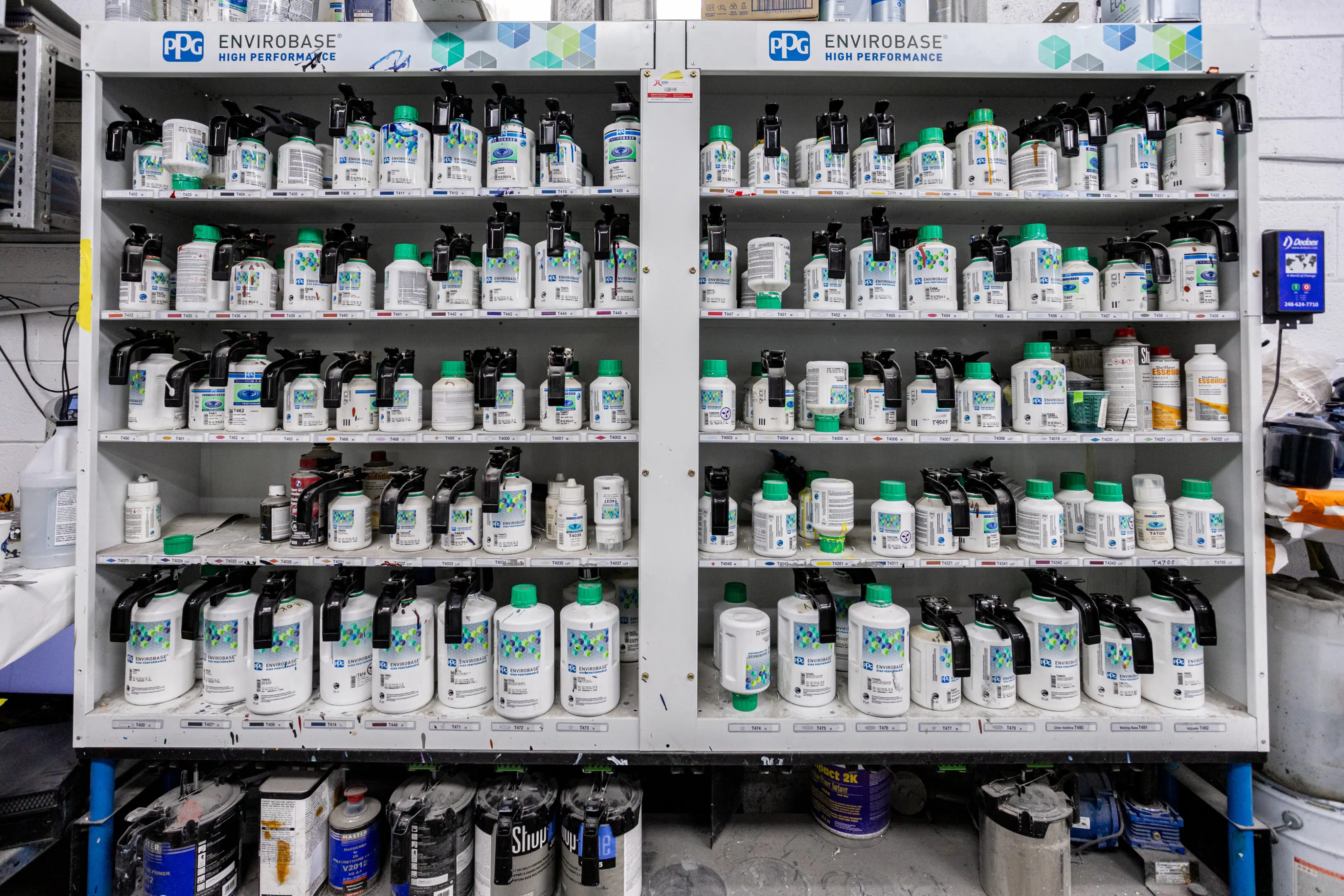 A shelf filled with many different bottles of paint.